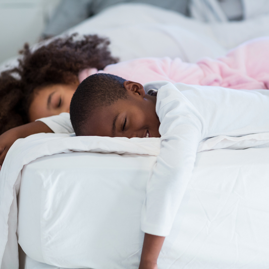 two children sleeping on a bed