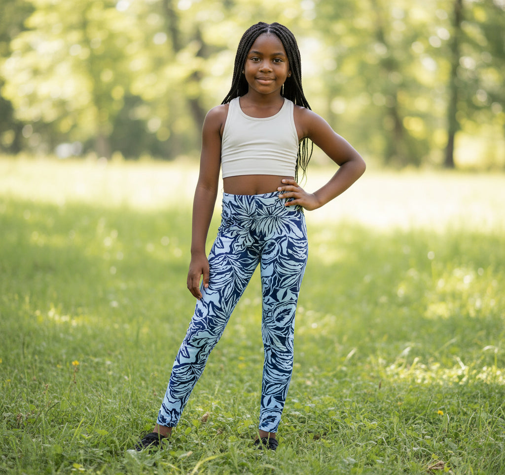 Blue floral-patterned leggings on a light gray surface with a small toy and color swatch in the background.
